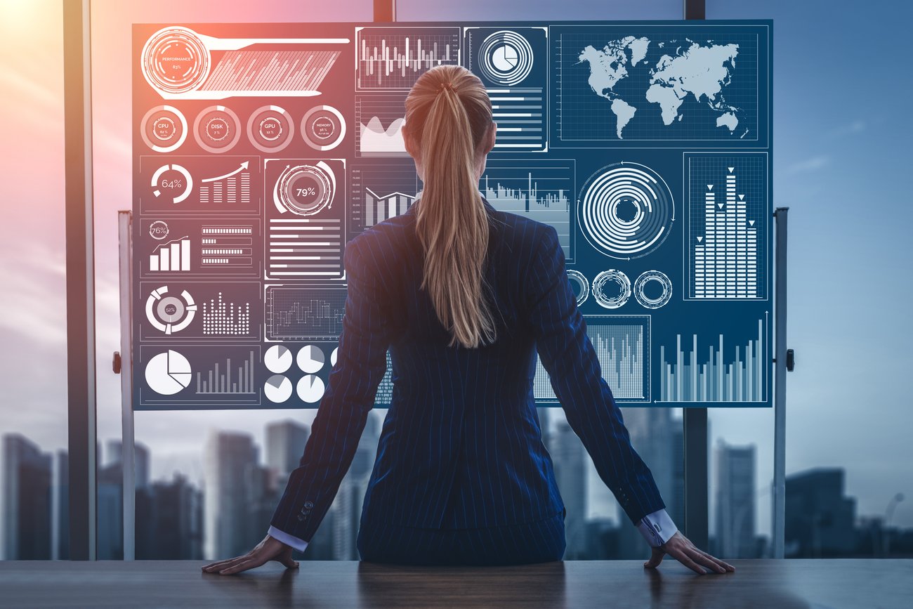 Confident businesswoman analyzing futuristic AI-powered financial dashboard with global charts and data projections